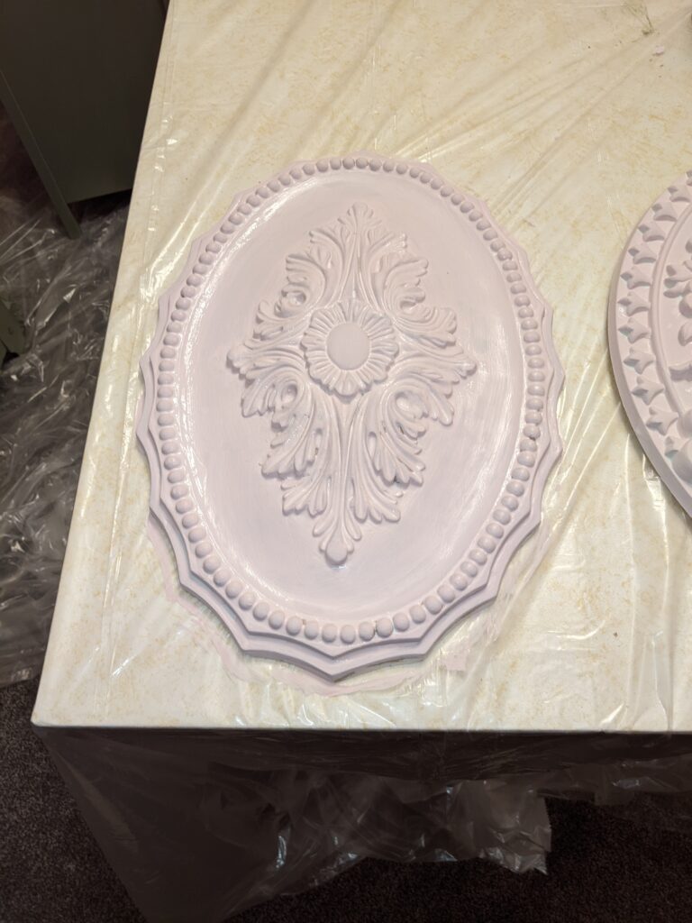 Oval ceiling medallion during the painting process.  It's light pink but will have brushes of grey and gold added to it.