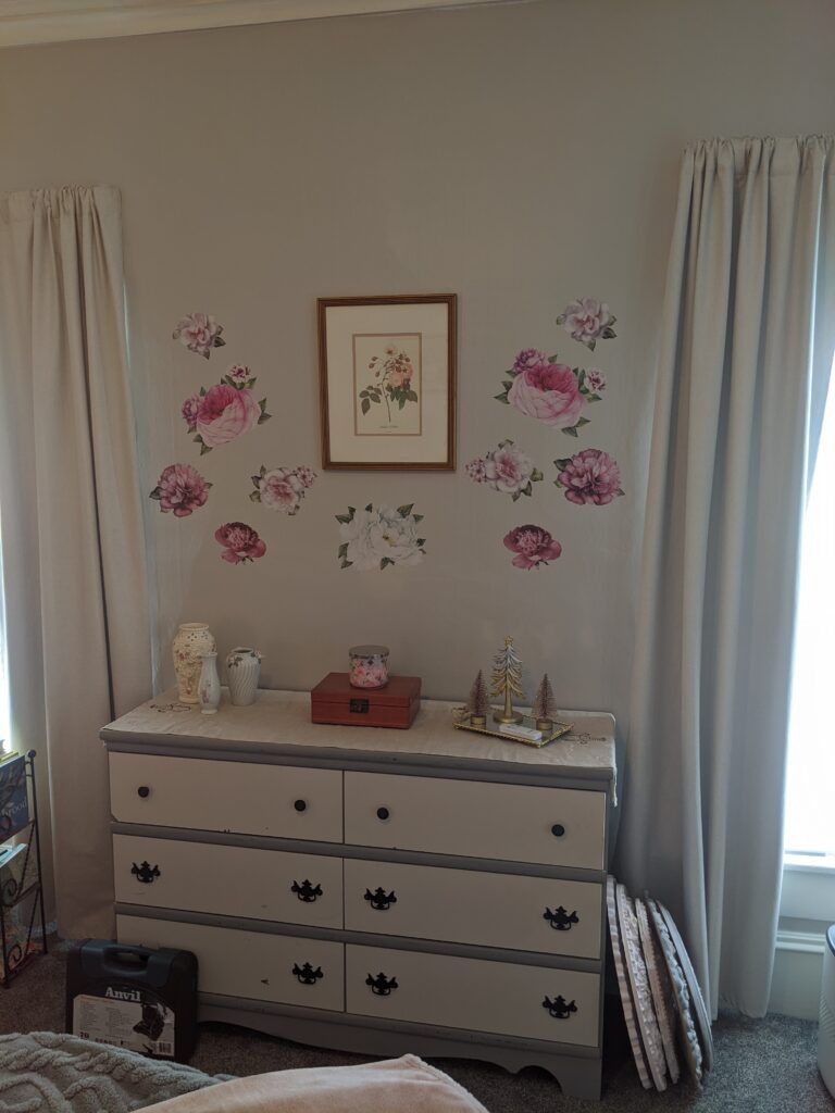 The before of the wall above the dresser prior to the painted ceiling medallion being hung above the art work and peel and stick floral decals.