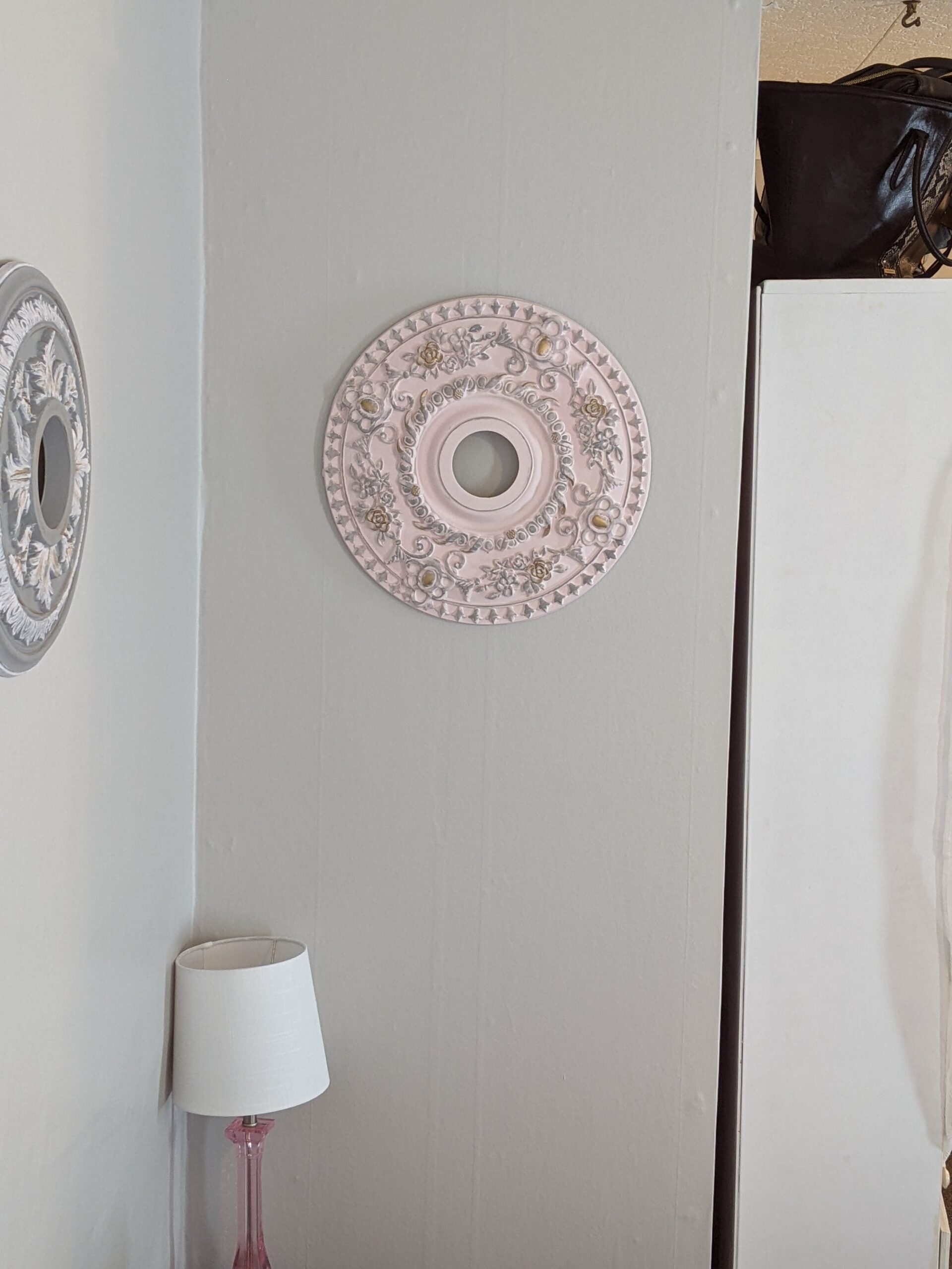 Light Pink with grey and gold brushed on of an upcycled Ceiling medallion that is now hanging on the wall as art.
